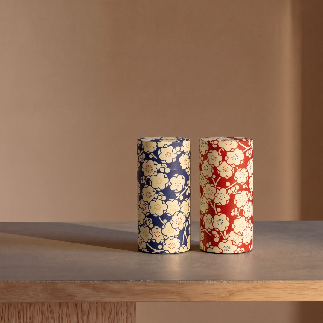 Boîtes à thé japonaises Yugen lab en fer blanc et papier washi, motifs floraux ivoire sur fonds bleu et rouge.