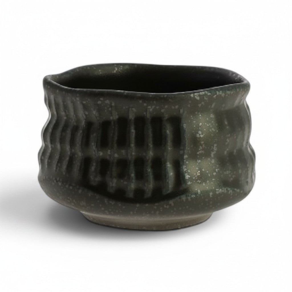Bol matcha Yugen lab en céramique noire avec texture verticale en relief, style japonais wabi-sabi.