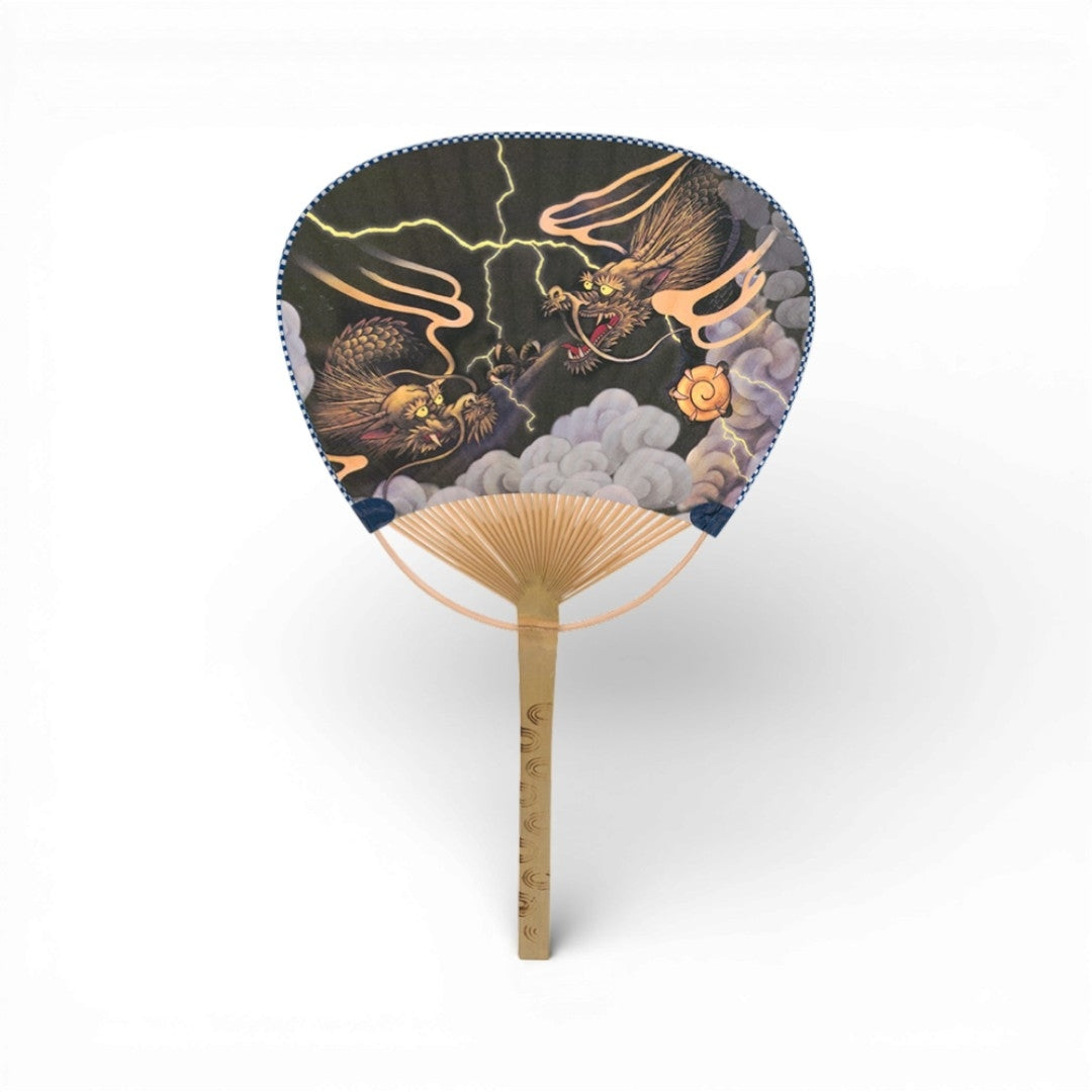 Éventail japonais en papier et bambou avec motif dragon au milieu des nuages et des éclairs.