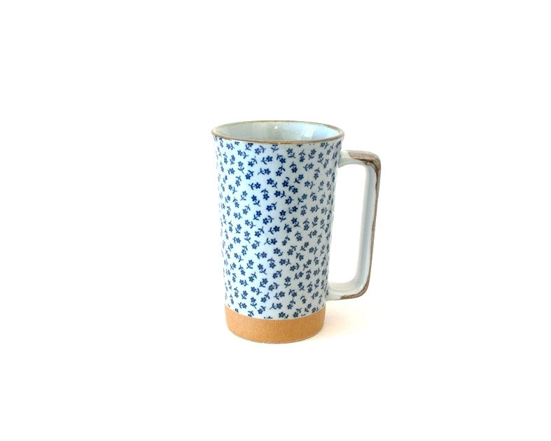 Mug grand fleur en céramique à motif floral bleu dense sur fond blanc.