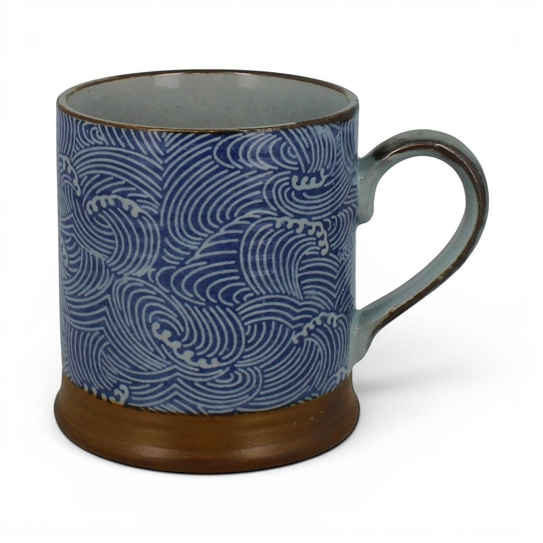 Vue de face d'un mug en porcelaine motif vagues bleues Shiranami avec anse sur fond blanc.