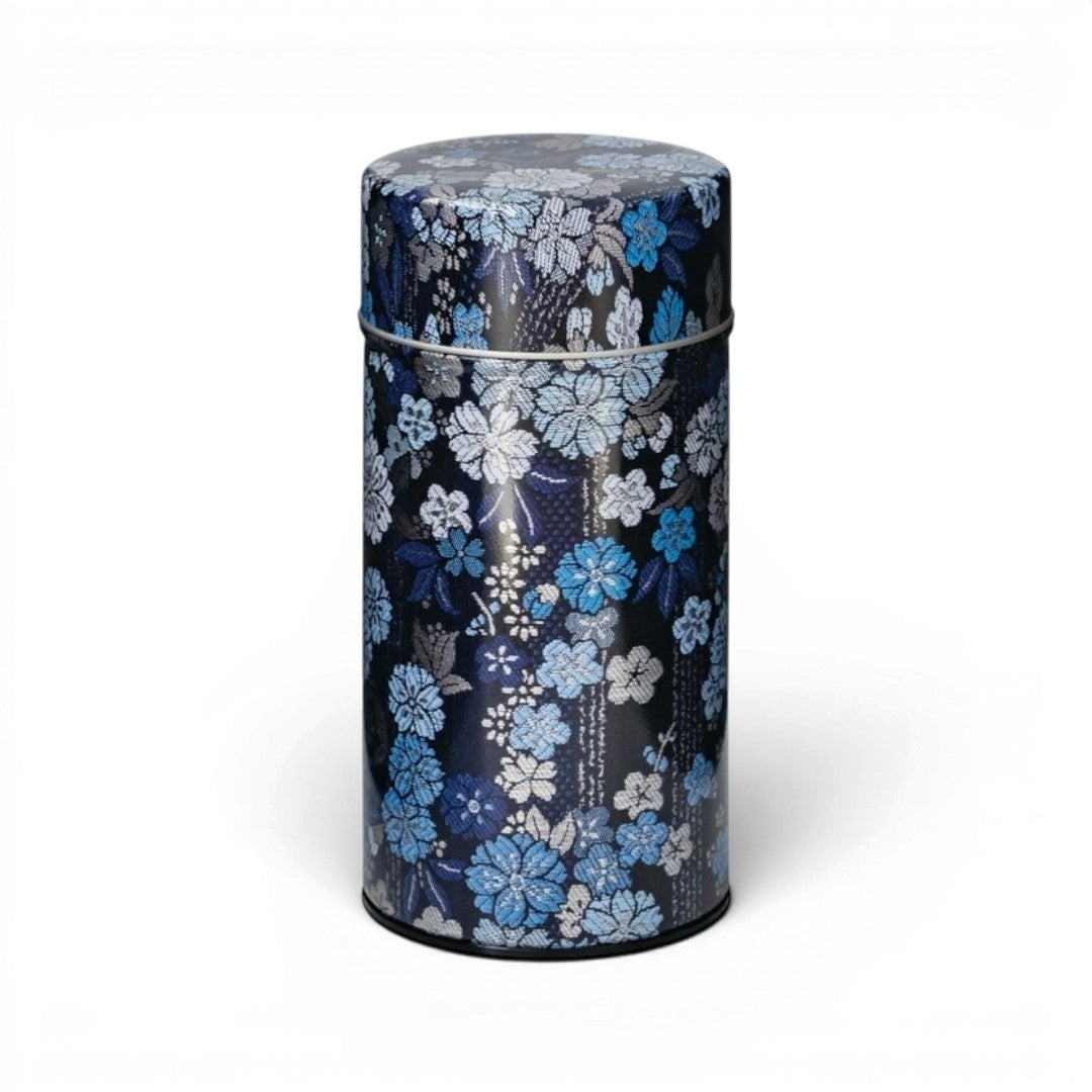 Boîte à thé Yugen lab cylindrique en fer blanc avec motif floral bleu et gris sur fond bleu nuit