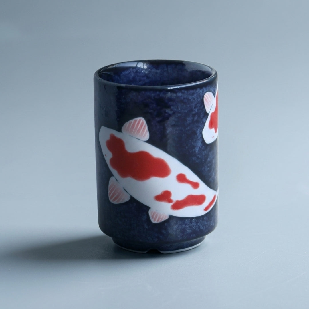 Yunomi japonais en porcelaine décoré de carpes koi sur fond bleu. Une tasse élégante de 7 × 10 cm idéale pour savourer le thé dans un esprit japonais.
