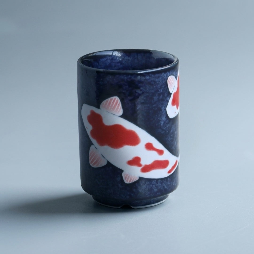Yunomi japonais en porcelaine décoré de carpes koi sur fond bleu. Une tasse élégante de 7 × 10 cm idéale pour savourer le thé dans un esprit japonais.
