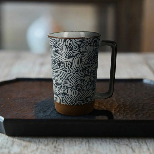 Mug japonais en céramique motif vagues Hokusai sur un plateau en bois.