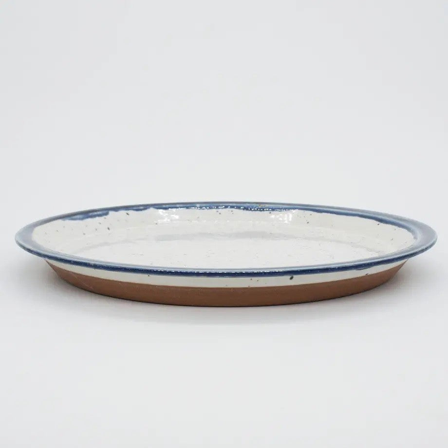 Assiette Yugen lab moderne en céramique blanche avec un contour bleu, style vaisselle japonaise artisanale