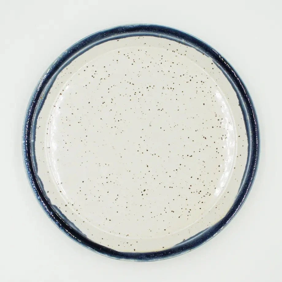 Assiette Yugen lab en céramique japonaise blanche mouchetée avec un contour bleu, vue de dessus