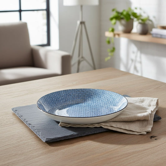 Assiette Yugen lab en céramique bleue à motif losange style japonais posée sur une ardoise et une serviette en lin