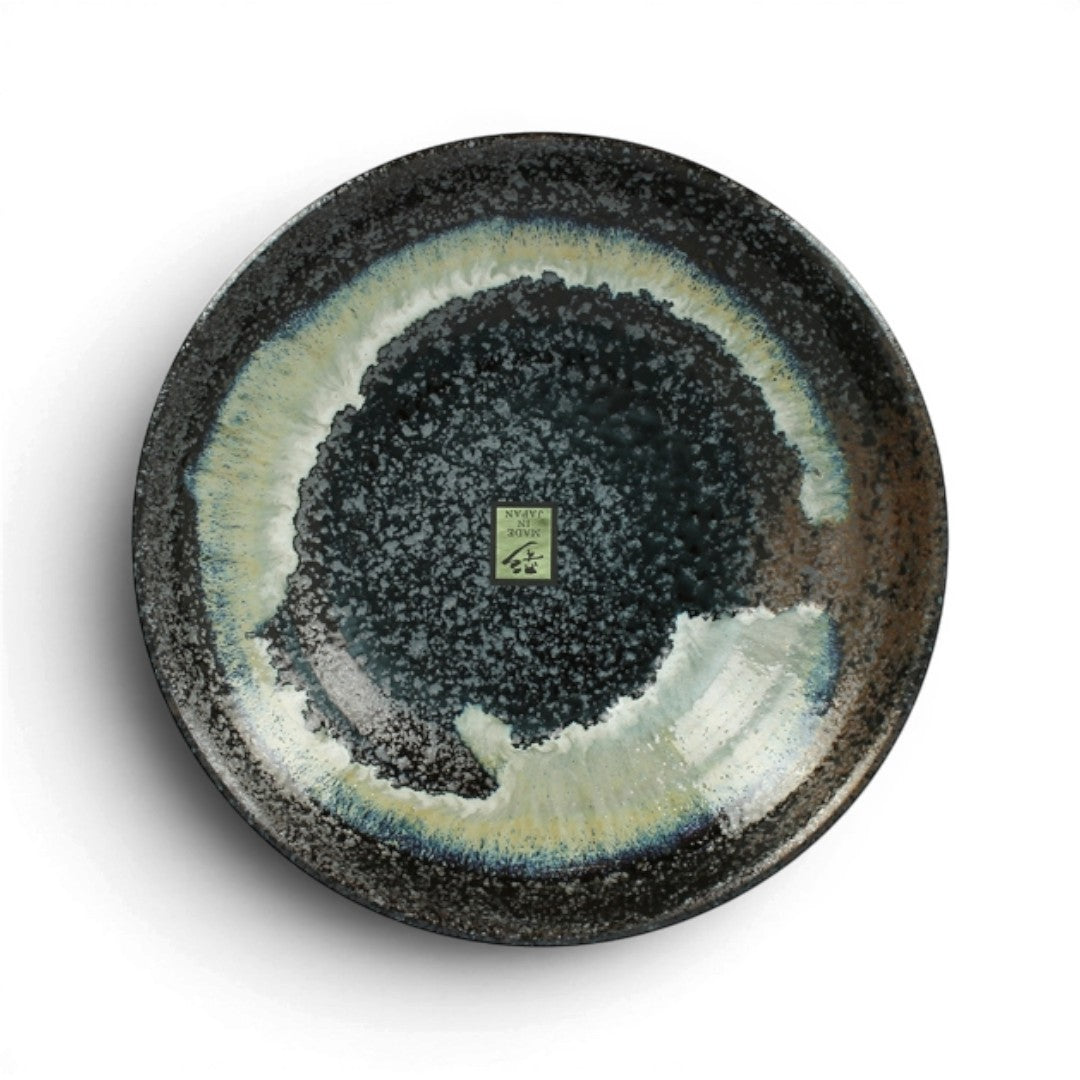 Assiette en céramique Yugen lab artisanale japonaise avec dégradés de bleu, noir et blanc, vue de dessus.