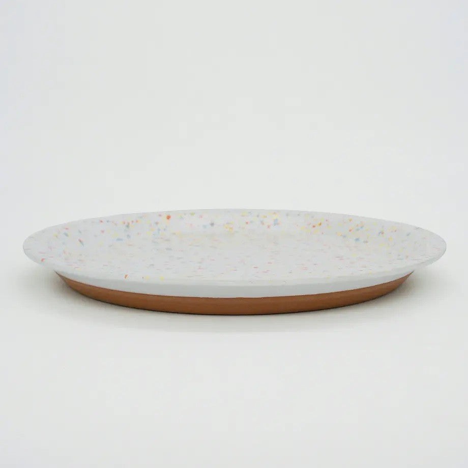 Assiette moderne en céramique Yugen lab blanche avec des éclats multicolores et un dessous en terre cuite naturelle
