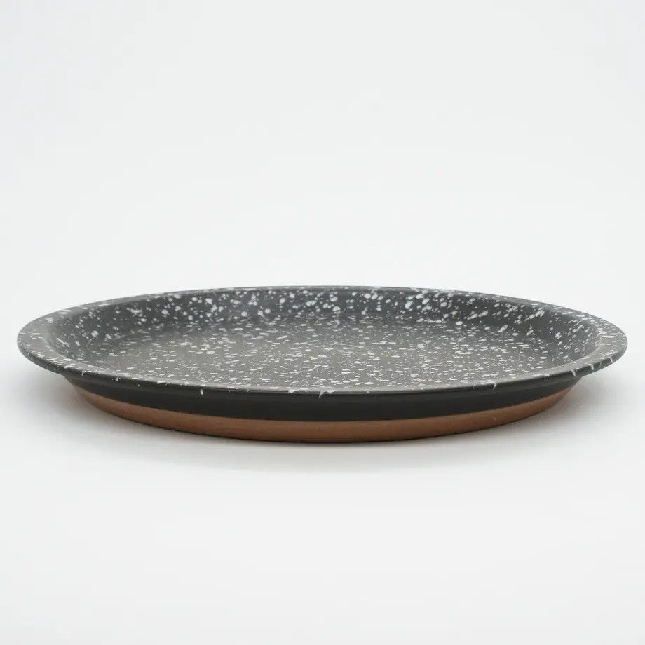 Assiette Yugen lab en céramique noire avec des éclats blancs, style japonais moderne et finition artisanale.