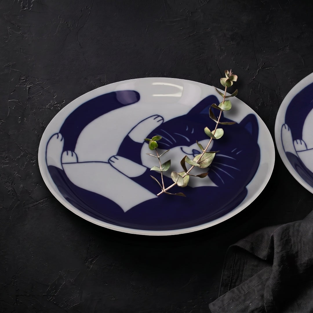 Set de 2 assiettes en porcelaine Yugen lab avec motif de chat bleu endormi sur fond blanc, style japonais graphique.
