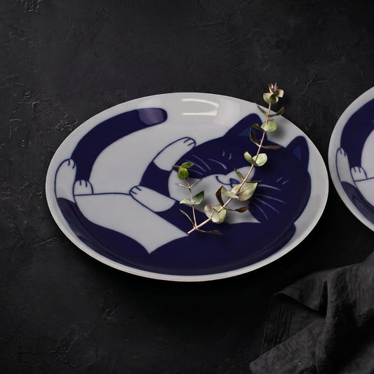 Set de 2 assiettes en porcelaine Yugen lab avec motif de chat bleu endormi sur fond blanc, style japonais graphique.