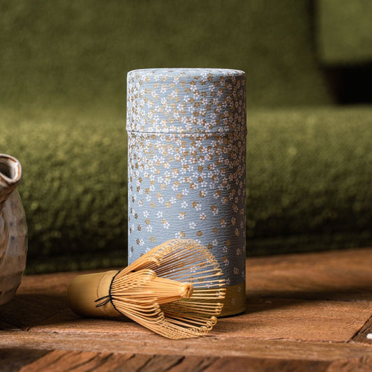 Boîte à thé Yugen lab cylindrique en fer blanc et papier washi bleu à motifs floraux blancs et dorés avec un chasen