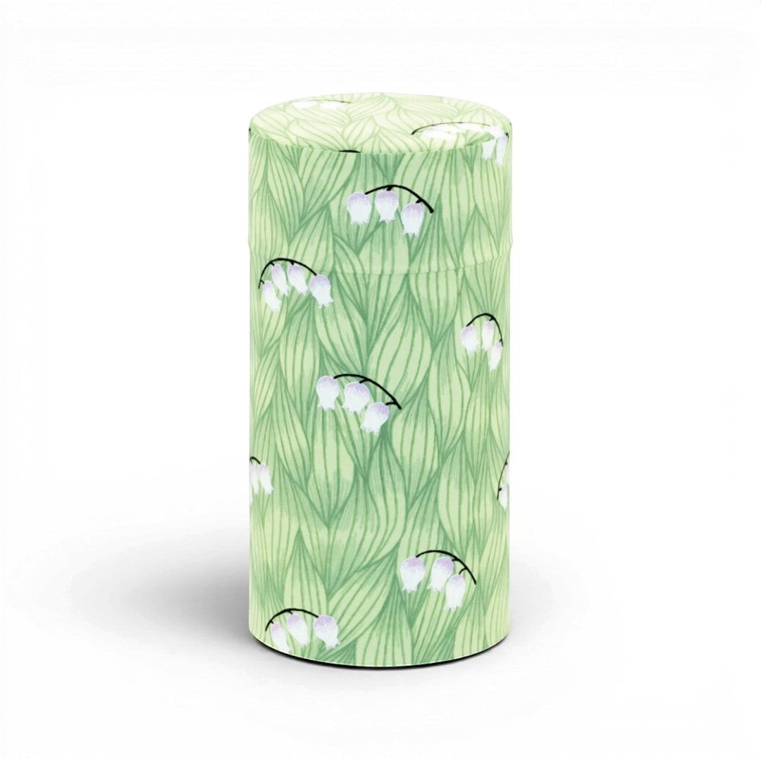 Boîte à thé cylindrique Yugen lab en fer blanc et papier washi vert avec un motif délicat de fleurs de muguet.