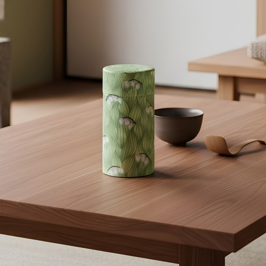 Boîte à thé Yugen lab cylindrique en fer blanc et papier washi vert avec motif de fleurs de muguet blanches
