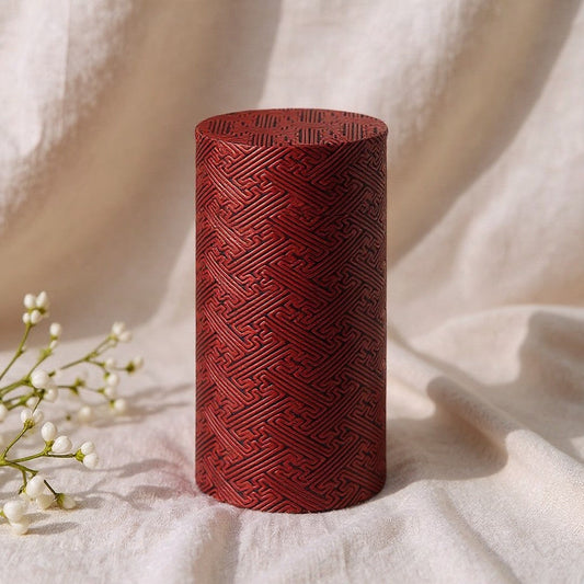 Boîte à thé Yugen lab cylindrique en fer blanc rouge avec un motif géométrique en relief façon tressage