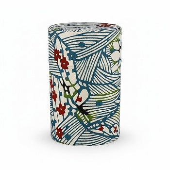 Boîte à thé Yugen lab cylindrique en fer blanc habillée de papier washi à motifs végétaux bleu indigo, rouge et vert.