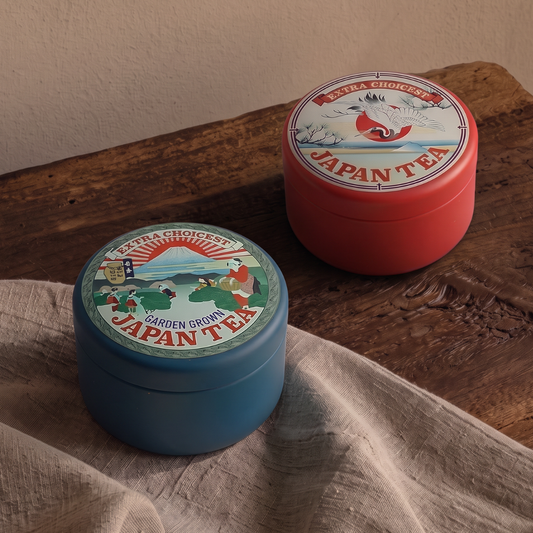 Deux boîtes à thé Yugen lab en fer blanc mat, l'une bleue avec le mont Fuji et l'autre rouge avec une grue japonaise.