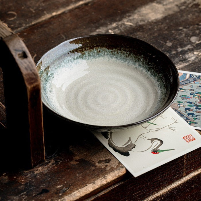 Bol japonais Yugen lab en céramique évasé avec intérieur gris clair et bordure brune sur une table en bois rustique