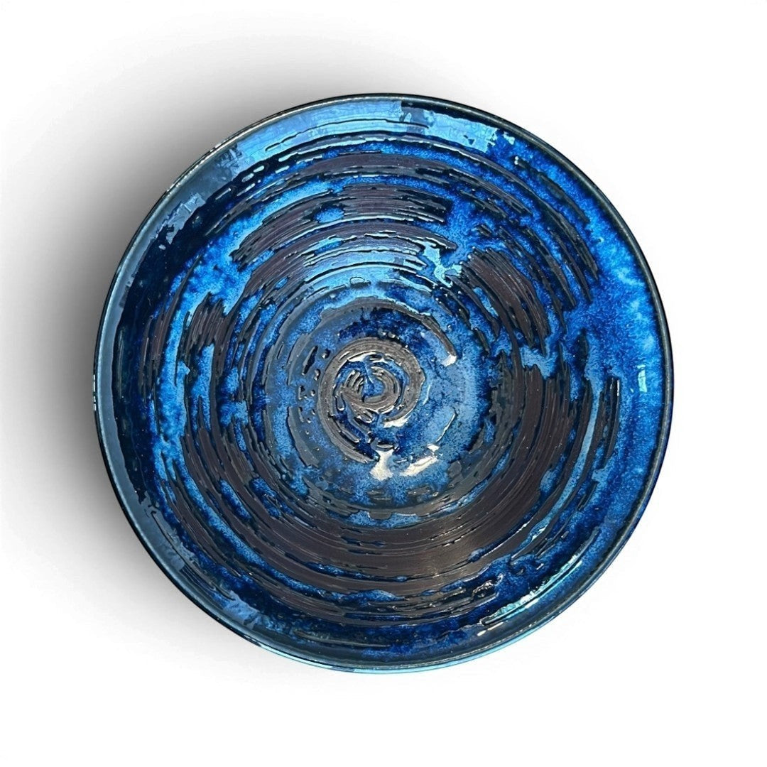 Bol donburi Yugen lab en céramique émaillée bleu profond avec un décor en relief effet tourbillon concentrique.