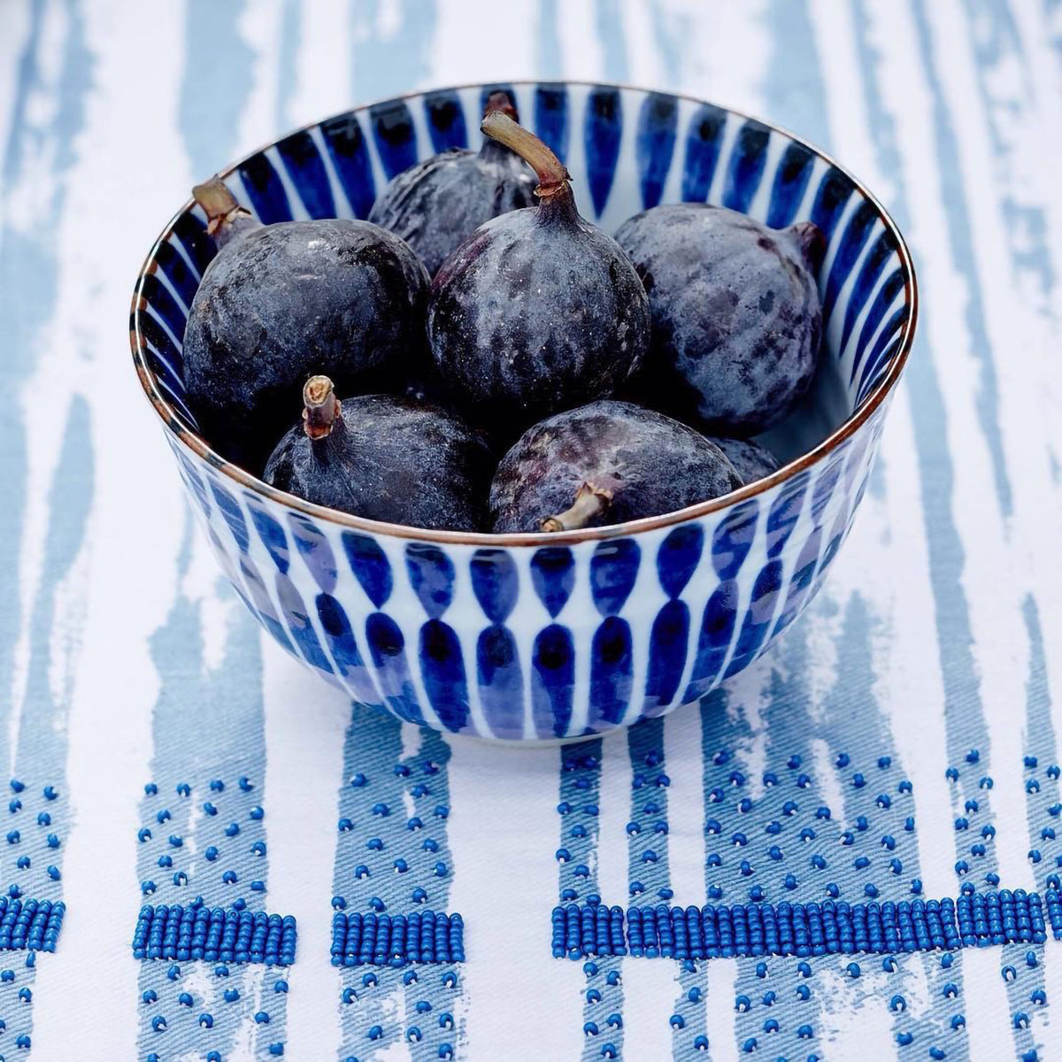 Bol à riz japonais Yugen lab en céramique blanche et bleue avec motif pinceaux verticale rempli de figues fraîches
