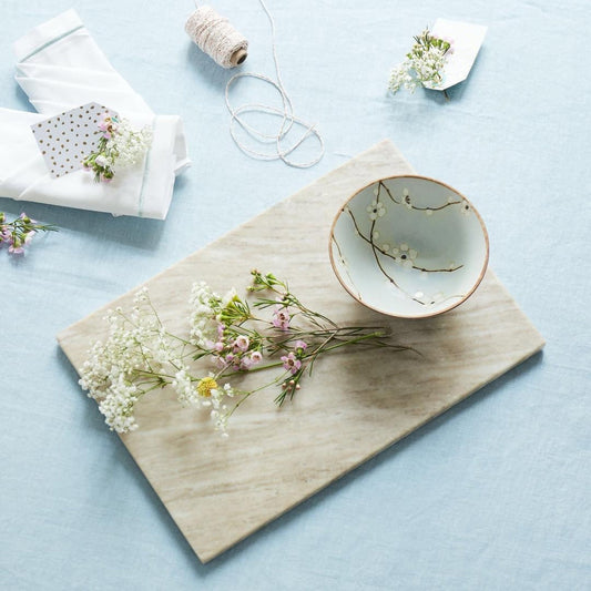 Bol japonais en céramique Yugen lab bleu clair avec motifs de fleurs blanches et lianes sur une planche en marbre