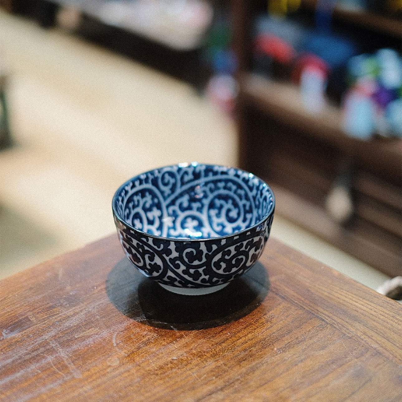 Bol japonais Yugen lab en porcelaine blanche et bleue avec motif traditionnel karakusa sur une table en bois