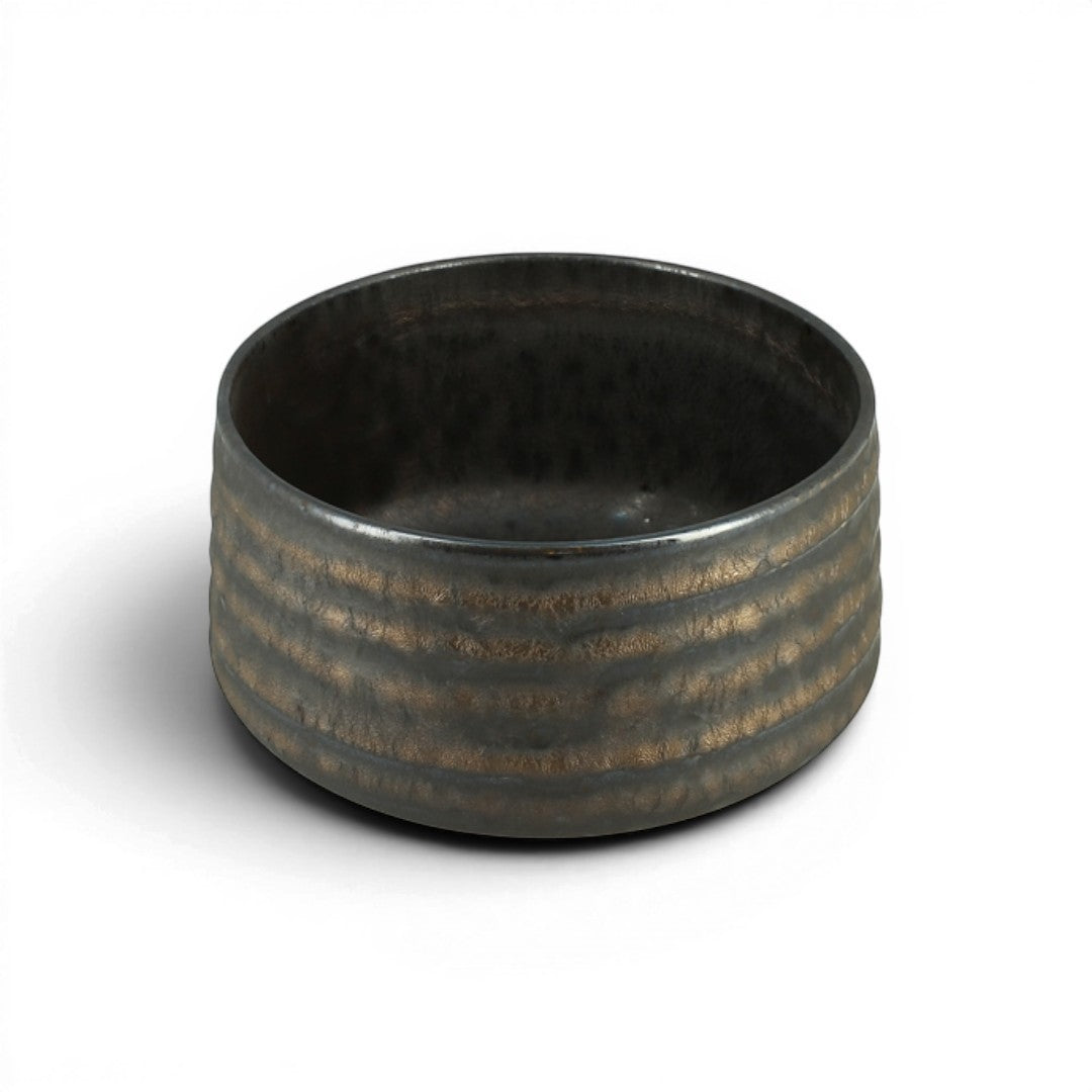 Bol à matcha Yugen lab en céramique sombre avec des reflets dorés et une texture striée, fabriqué au Japon.
