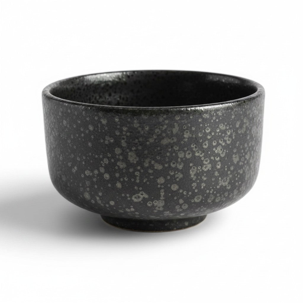 Petit bol matcha Yugen lab en céramique noire mate avec une texture minérale mouchetée et un style japonais wabi-sabi.