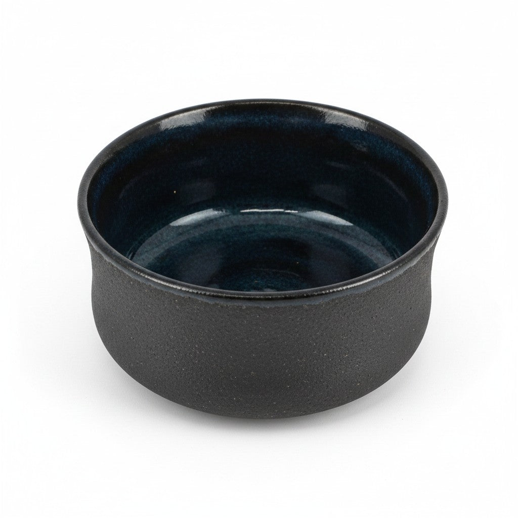 Bol matcha Yugen lab en céramique noire texturée avec intérieur émaillé vert profond, style wabi-sabi japonais