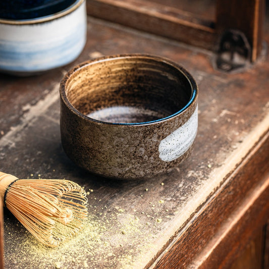 Bol à matcha Yugen lab en céramique artisanale marron avec motif blanc, accompagné d'un fouet en bambou