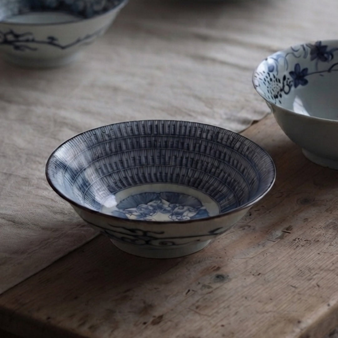Bol à ramen Yugen lab en porcelaine blanche et bleue avec motif traditionnel japonais, posé sur une table en bois.