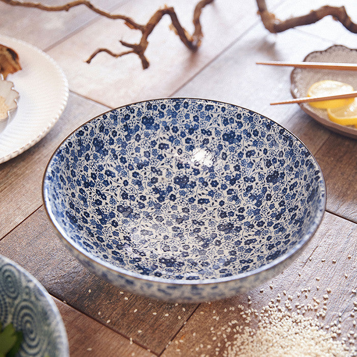 Bol à riz japonais Yugen lab en céramique et porcelaine avec un motif floral bleu et blanc sur fond clair