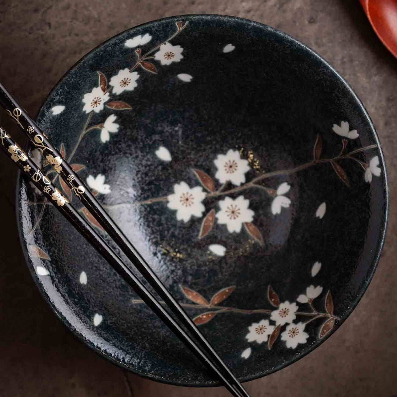 Bol à riz Yugen lab en porcelaine noire orné de fleurs de sakura blanches et de baguettes assorties