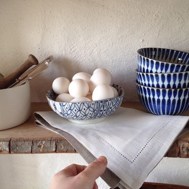 Set de 4 bols japonais Yugen lab en céramique blanche et bleue avec motifs traditionnels, empilés sur une étagère.