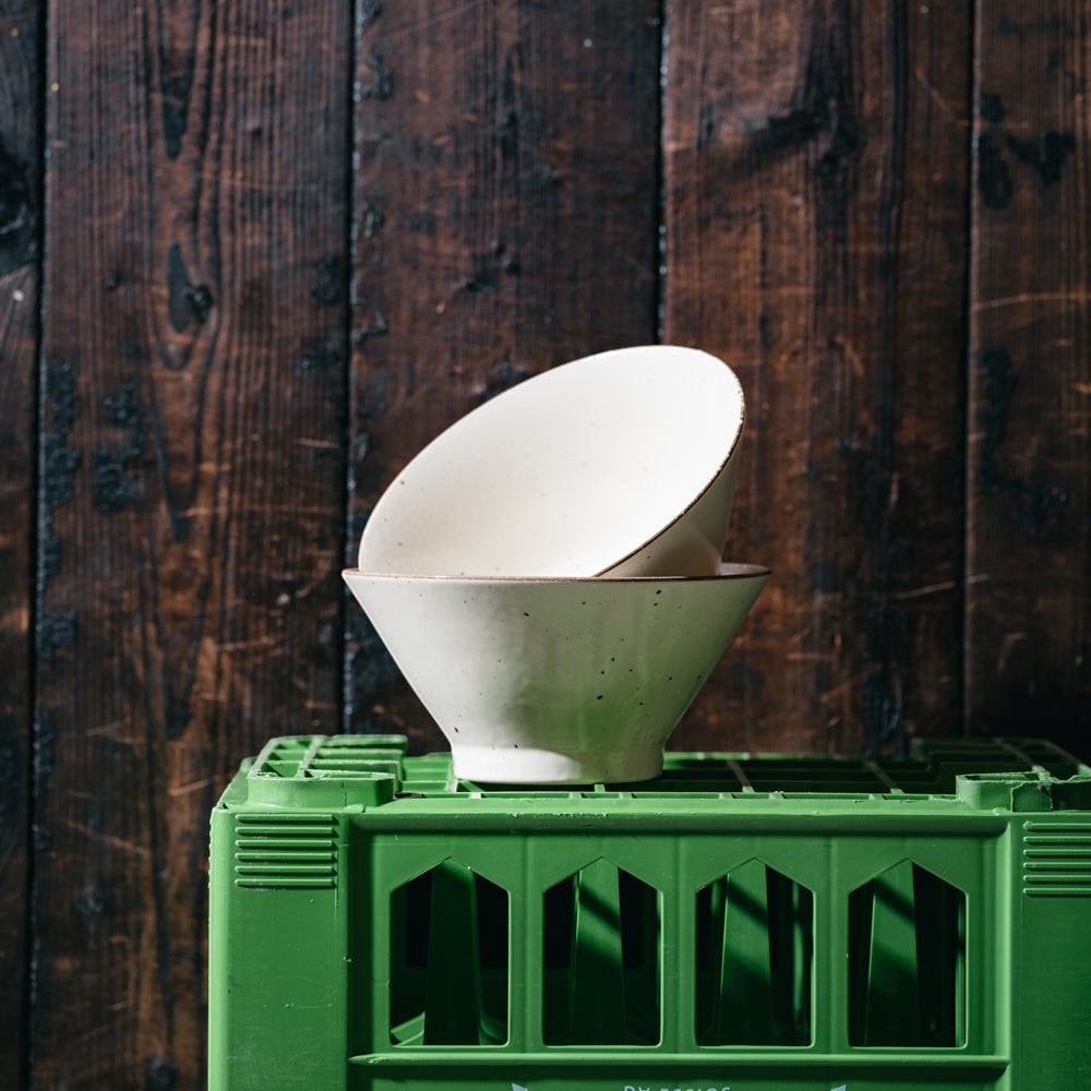 Set de deux bols japonais Yugen lab beiges pour ramen au design artisanal épuré posés sur une caisse verte