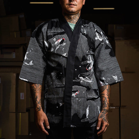 Homme tatoué portant une chemise japonaise happi noire Yugen lab avec un motif de carpes koï blanches et fluides