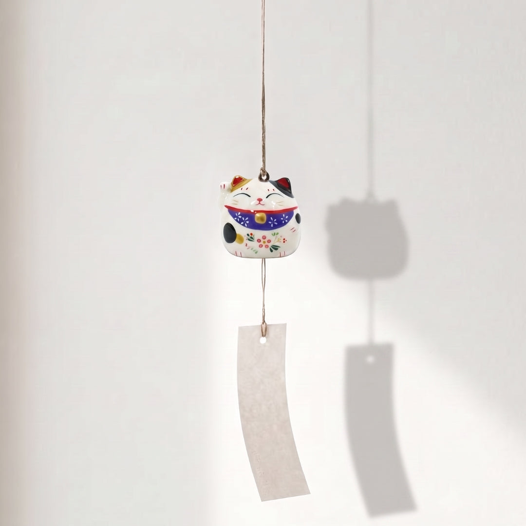 Cloche japonaise Yugen lab en porcelaine blanche forme Maneki Neko avec détails violets et bande de papier suspendue