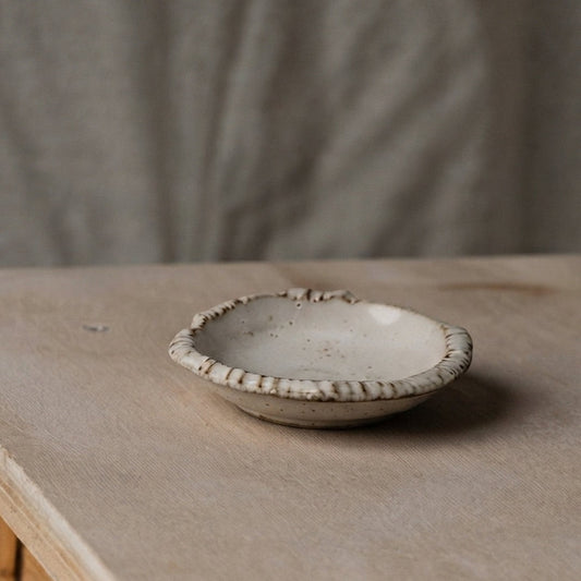 Coupelle Yugen lab en céramique beige mouchetée avec bord irrégulier texturé, style wabi-sabi pour condiments.