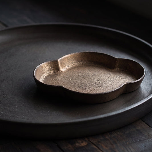 Coupelle japonaise Yugen lab en porcelaine brune aux reflets bronze, forme organique irrégulière et texture fine.