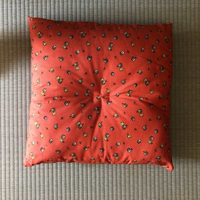 Coussin Yugen lab en coton rouge avec motifs japonais traditionnels posé sur un sol en tatami