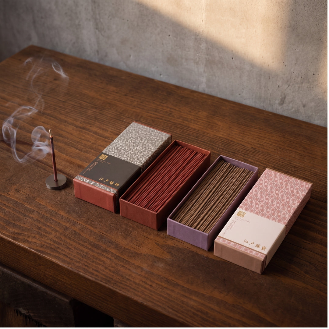 Boîtes d'encens japonais Yugen lab Nishiki Tsuya avec bâtonnets parfumés, motifs asanoha et fumée sur table en bois