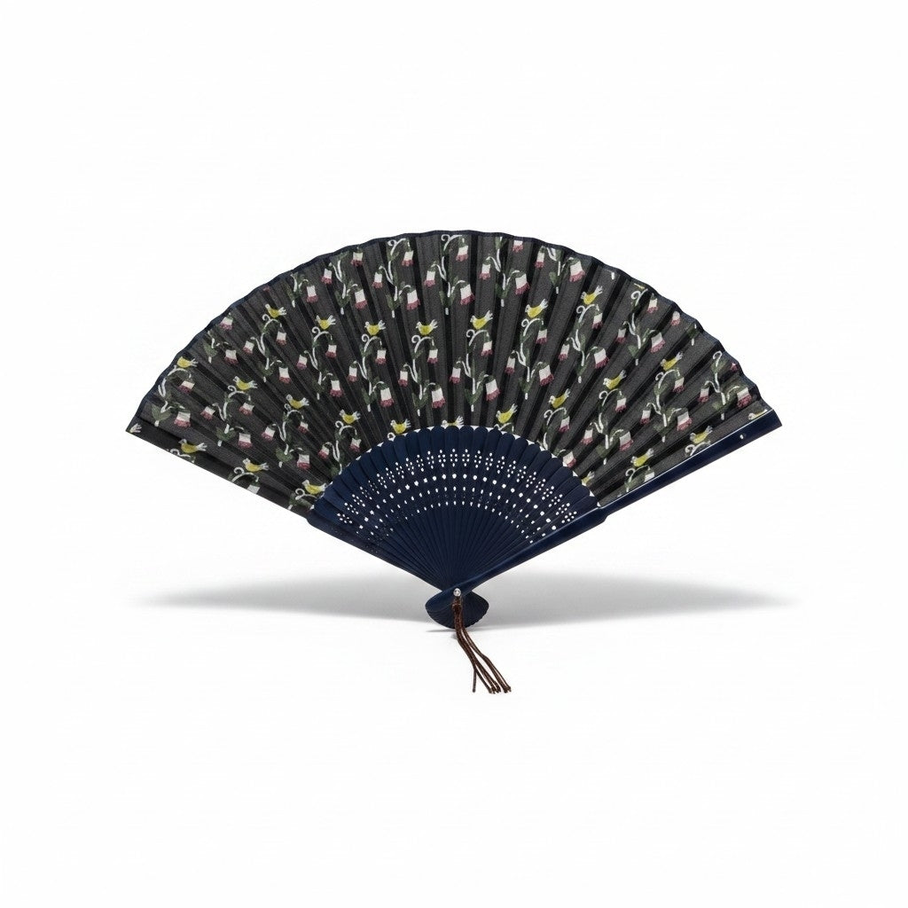 Éventail japonais Yugen lab en tissu bleu foncé avec motifs de fleurs et oiseaux jaunes, monture ajourée et pompon.