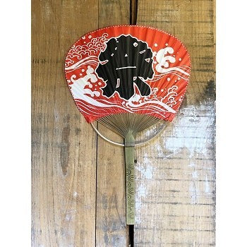 Éventail japonais Yugen lab rouge avec motif de vagues Seigaiha et manche en bambou sur fond bois