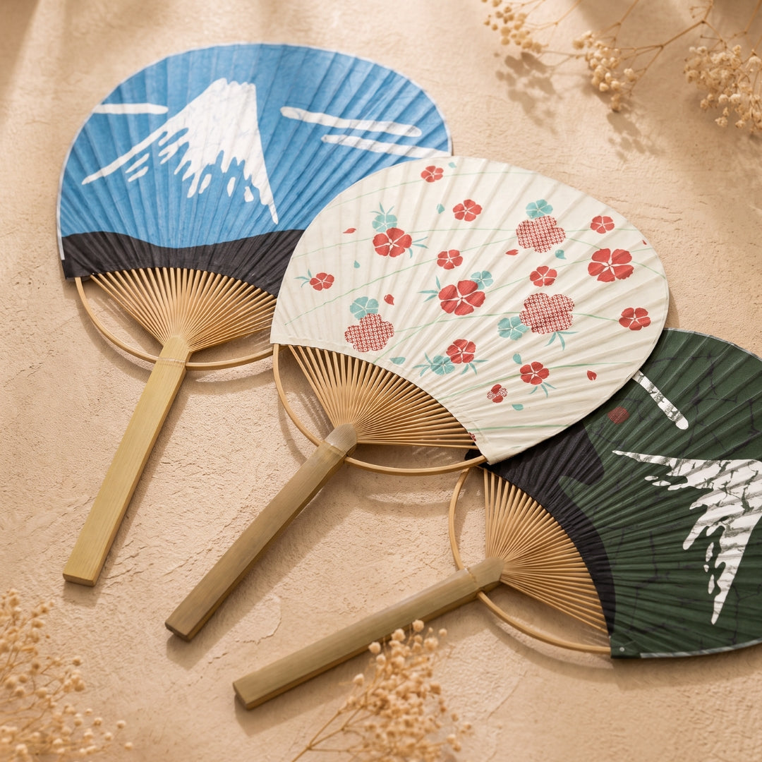 Trois éventails japonais ronds Uchiwa Yugen lab en papier et bambou avec motifs mont Fuji et fleurs rouges.