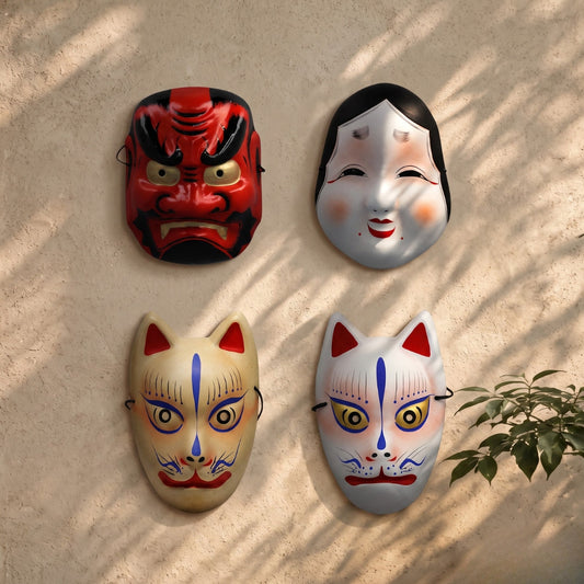 Quatre masques japonais Yugen lab en papier cartonné rigide : Tengu rouge, Okame souriant, et deux Kitsune renards.