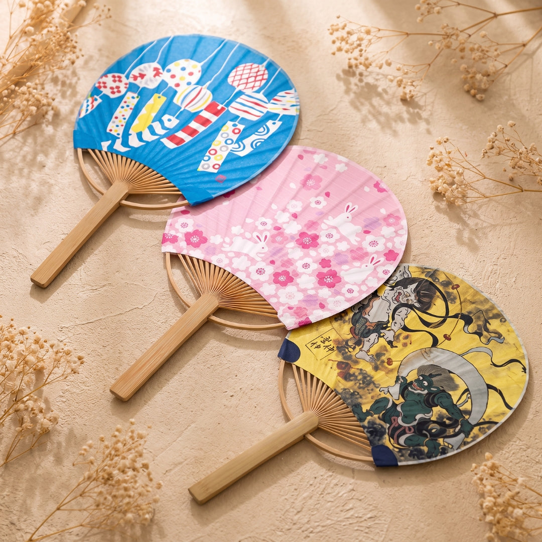 Trois mini éventails japonais uchiwa Yugen lab avec motifs koinobori bleus, lapins roses et personnages jaunes
