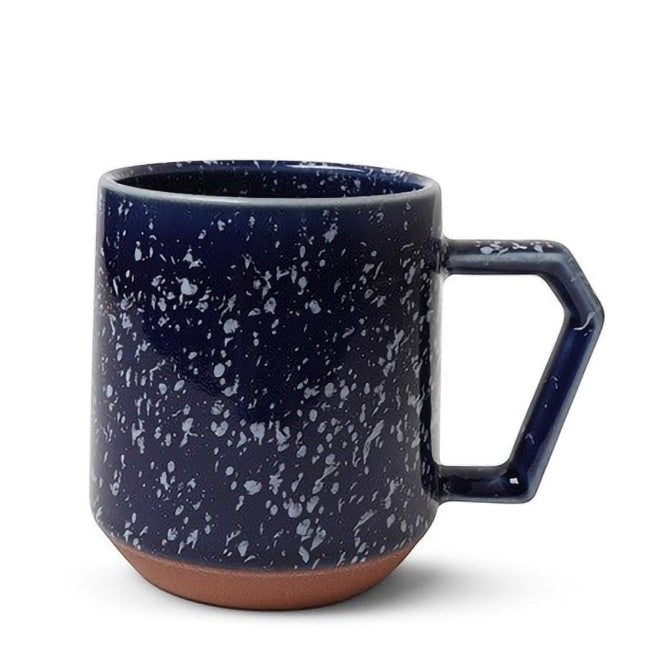 Mug Yugen lab en céramique bleu foncé avec motif moucheté et anse géométrique sur fond blanc
