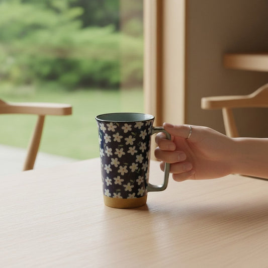 Mug en céramique Yugen lab bleu avec motif floral blanc Kobana et anse rectangulaire sur une table en bois